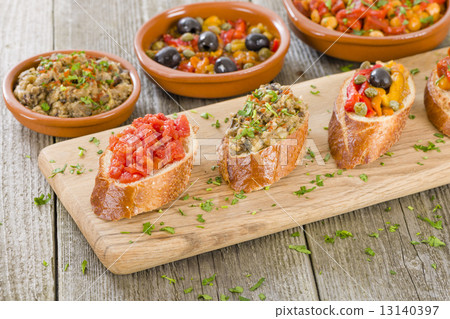 Tapas on Crusty Bread - Selection of Spanish tapas served on a sliced baguette. Tapas on Crusty Bread - Selection of Spanish tapas served on a sliced baguette. 13140397