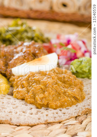 Ethiopian Feast - Injera with doro wat, yebeg alicha, misir wat, kik alicha, and gomen  13140559