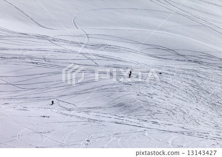 Silhouettes of snowboarders and skiers on off piste slope 13143427