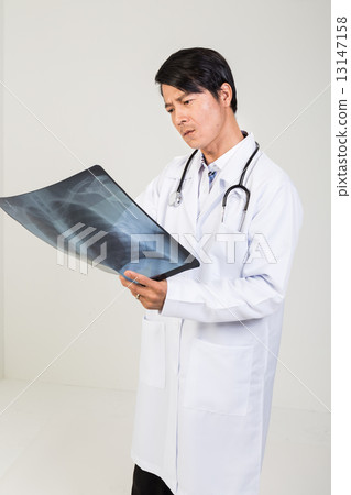 Medical doctor examining x-ray film of a lung Medical doctor examining x-ray film of a lung 13147158
