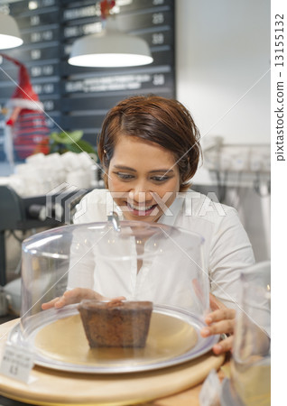 Asian baker promoting her last piece of chocolate cake. 13155132