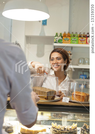 An Asian waitress happily serving a customer.  13159350
