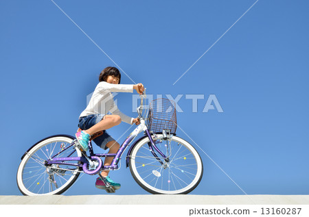 A girl riding a bicycle A girl riding a bicycle 13160287
