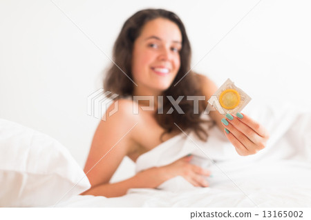 Girl with condom in bed 13165002