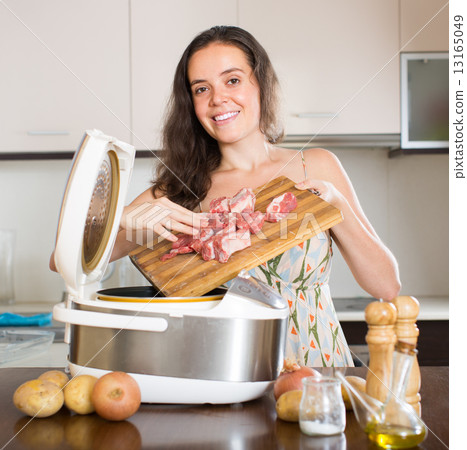 Woman cooking with electric multicooker 13165049