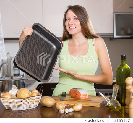 Smiling housewife cooking salmon Smiling housewife cooking salmon 13165197