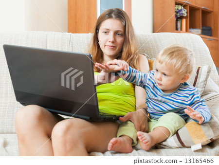 sorehead woman with baby working with computer sorehead woman with baby working with computer 13165466