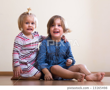 little girls sitting on floor 13165498