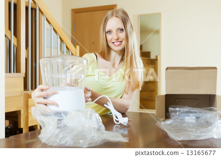 Smiling young woman with electric steamer Smiling young woman with electric steamer 13165677