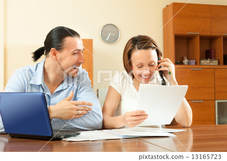 Happy couple looking financial document Happy couple looking financial document 13165723