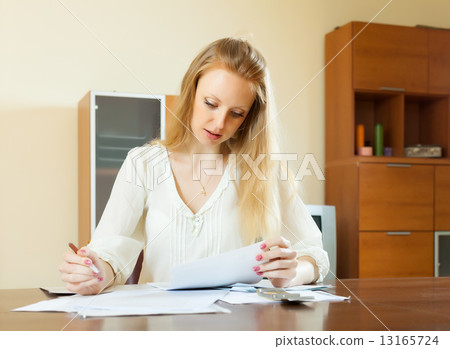 serious long-haired woman fills in questionnaire serious long-haired woman fills in questionnaire 13165724