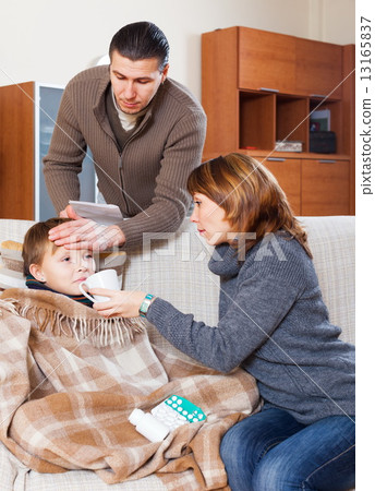 Parents giving tablets to son 13165837