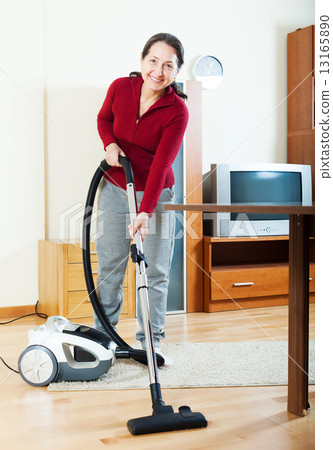 Happy mature woman with vacuum cleaner Happy mature woman with vacuum cleaner 13165890