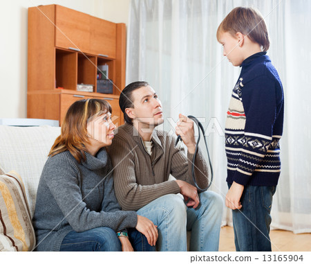 Mother and father with belt berating boy Mother and father with belt berating boy 13165904