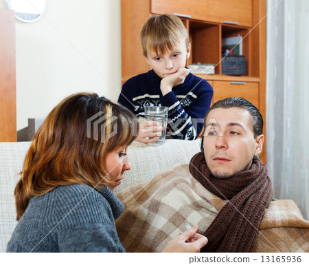 Ailing man surrounded by caring family Ailing man surrounded by caring family 13165936