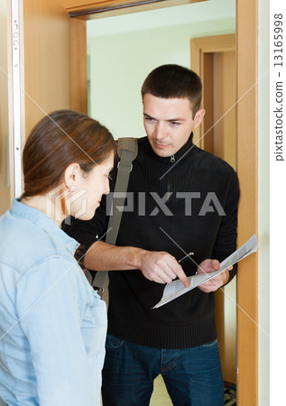 businessman trying to collect money from housewife 13165998