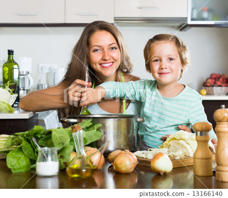 Mother with little daughter cooking at home Mother with little daughter cooking at home 13166140