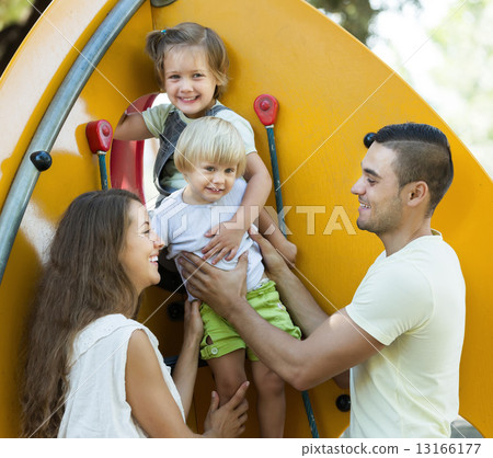 Smiling parents helping children on stairs Smiling parents helping children on stairs 13166177