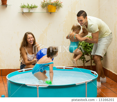 Family playing in pool at terrace 13166201
