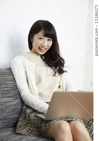 A woman using a personal computer in a room A woman using a personal computer in a room 13166271