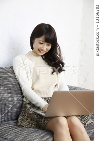 A woman using a personal computer in a room 13166283