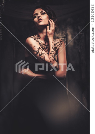 Tattooed beautiful woman in old spooky interior 13168458