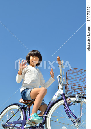 A girl riding a bicycle 13173374