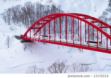 Niigata ken Uonuma sightseeing bus running in heavy snow and red bridge 13178319