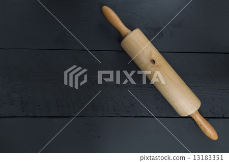 Rolling pin on a black wood as the background 13183351