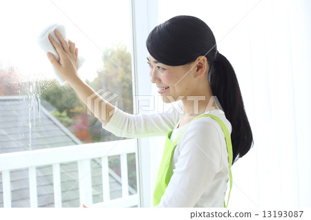 A woman wiping a windowpane A woman wiping a windowpane 13193087