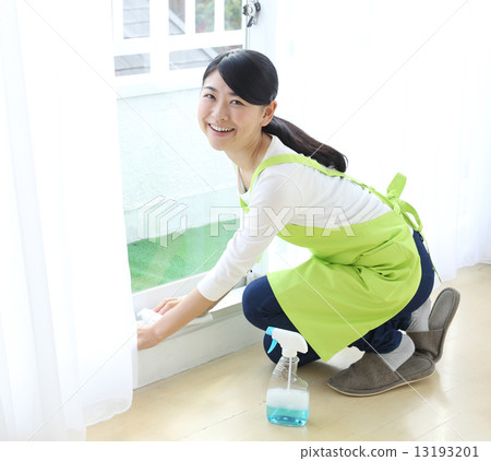 A woman wiping a window frame A woman wiping a window frame 13193201