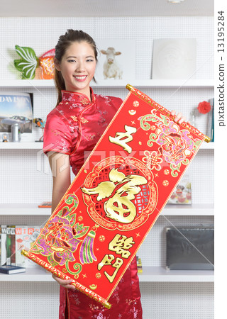 One young Chinese woman in cheongsam holding 5 good fortunes red banner in front of bookshelf 13195284