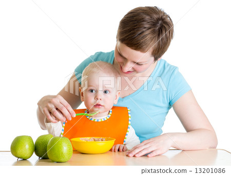 Mother spoon-feeding her baby 13201086
