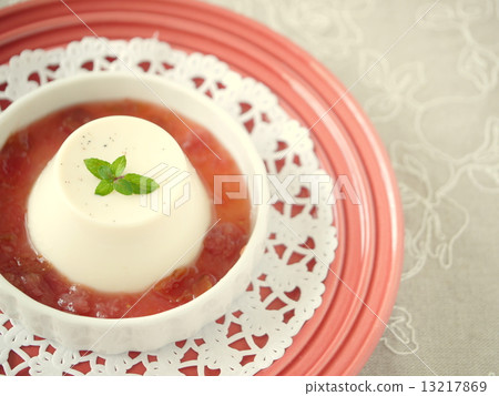 Milk pudding with red fruit sauce (sideways high angle) 13217869