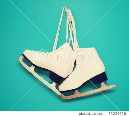 white ice skates for figure skating, hanging on a blue backgroun 13224616