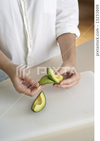 Hand peeling avocado 13231609