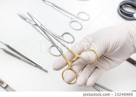 metallic surgical instrument in the surgeon's hand 13248469