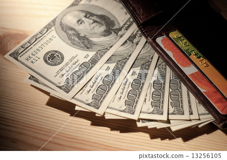 Brown Wallet with credit cards and dollar banknotes over wooden Brown Wallet with credit cards and dollar banknotes over wooden 13256105