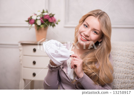 Young attractive woman holding baby hat , interior shot 13258917