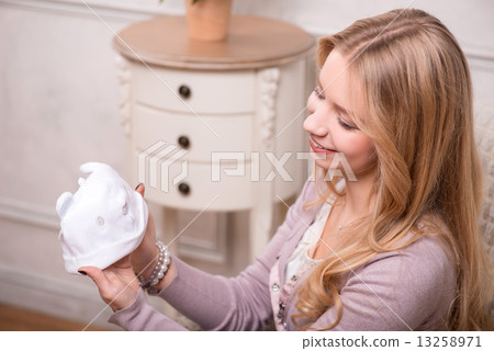 Young attractive woman holding baby hat, interior shot Young attractive woman holding baby hat, interior shot 13258971