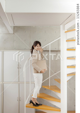 A woman standing up the stairs in the office A woman standing up the stairs in the office 13263864