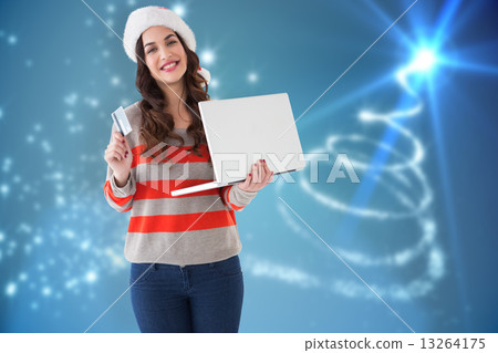 Composite image of festive brunette holding laptop and credit ca Composite image of festive brunette holding laptop and credit ca 13264175
