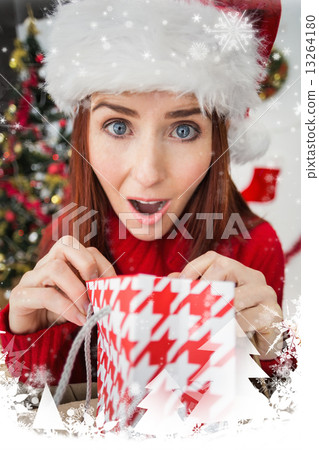 Composite image of festive redhead opening christmas gift Composite image of festive redhead opening christmas gift 13264180