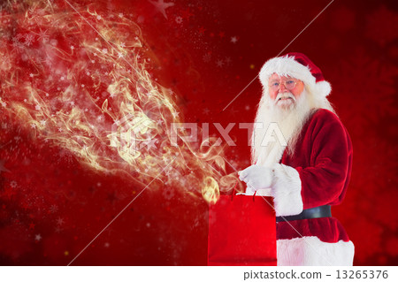 Composite image of santa carries red gift bag 13265376