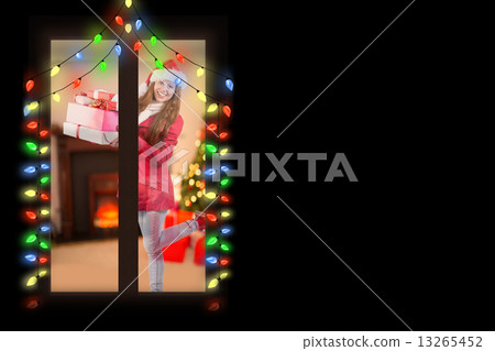 Composite image of festive redhead holding pile of gifts Composite image of festive redhead holding pile of gifts 13265452