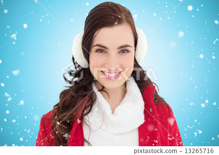 Composite image of portrait of a smiling brunette with winter we Composite image of portrait of a smiling brunette with winter we 13265716