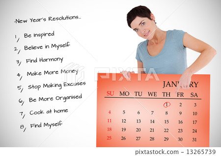 Composite image of smiling woman pointing at calendar on a panel 13265739