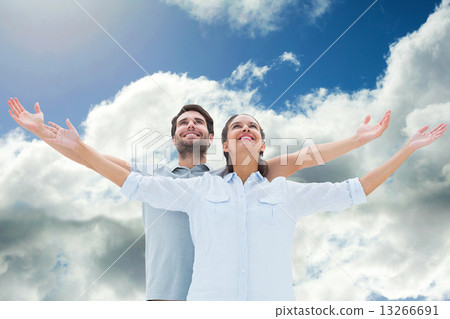 Composite image of cute couple standing with arms out 13266691