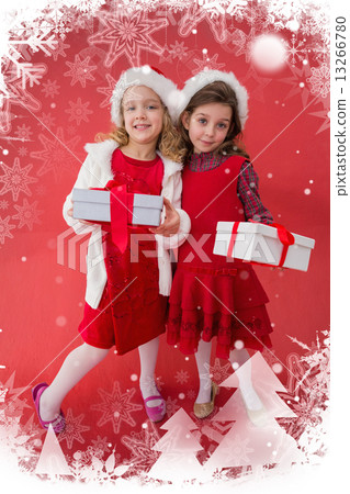 Composite image of festive little girls smiling at camera with gifts Composite image of festive little girls smiling at camera with gifts 13266780