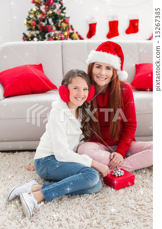 Composite image of festive mother and daughter opening a christmas gift Composite image of festive mother and daughter opening a christmas gift 13267385